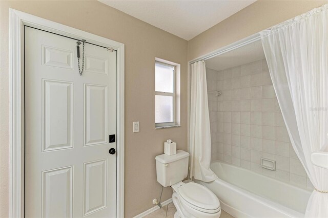 bathroom featuring tile patterned flooring, toilet, and shower / bathtub combination with curtain