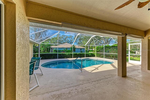 view of swimming pool with a lanai, ceiling fan, and a patio area