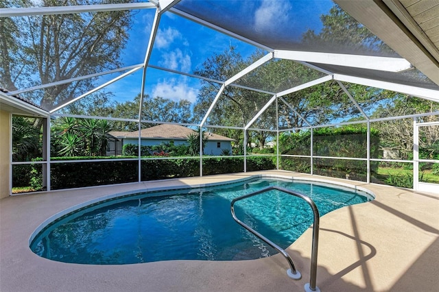 view of pool with a patio area and glass enclosure