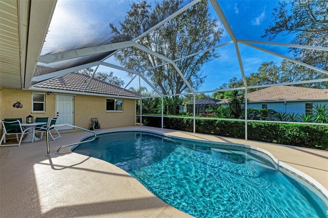 view of swimming pool featuring a lanai and a patio area