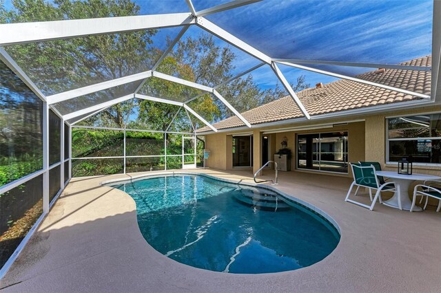 view of pool featuring glass enclosure and a patio