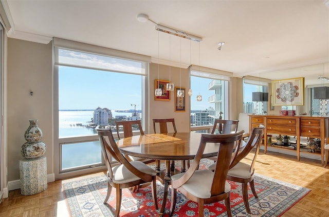 dining room featuring parquet floors, a wealth of natural light, and a water view