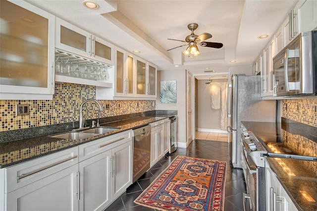 kitchen featuring dark tile patterned floors, a tray ceiling, white cabinetry, and stainless steel appliances