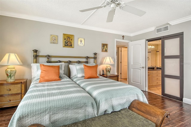 bedroom featuring a textured ceiling, ensuite bath, ceiling fan, and crown molding