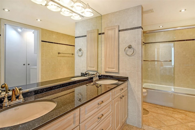 full bathroom with vanity, tile walls, enclosed tub / shower combo, tile patterned flooring, and toilet