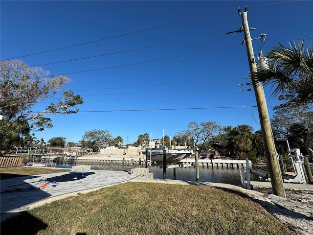 view of yard featuring a water view and a boat dock