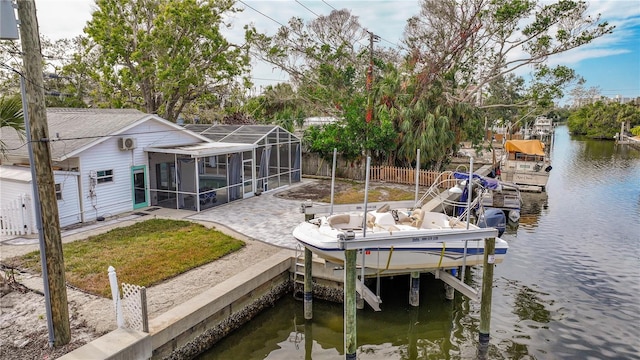 view of dock with glass enclosure, a water view, a yard, and a patio