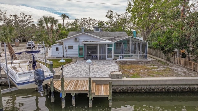 rear view of house with a lanai, a sunroom, and a water view