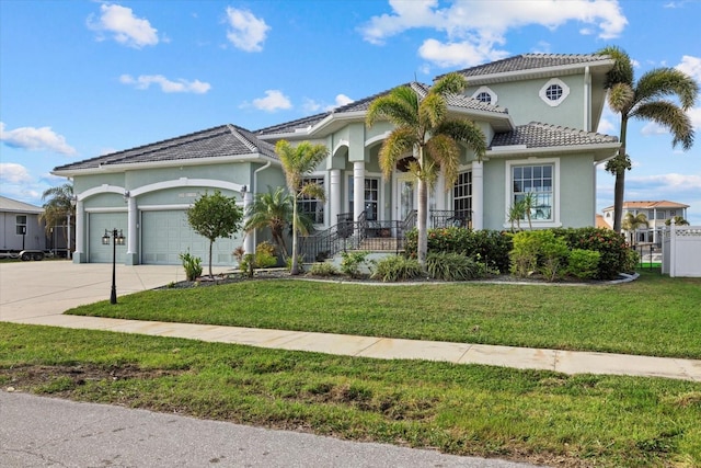 mediterranean / spanish house featuring a porch, a garage, and a front lawn