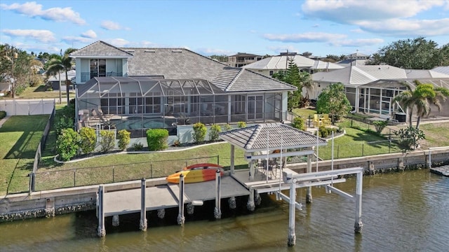 view of dock with a yard, a water view, and a lanai