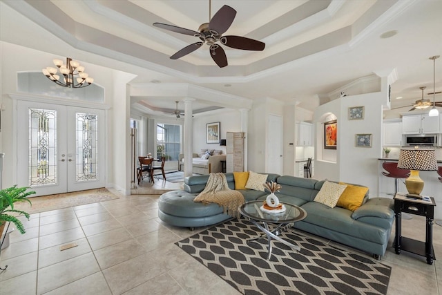 living room featuring french doors, light tile patterned floors, a raised ceiling, and ornamental molding