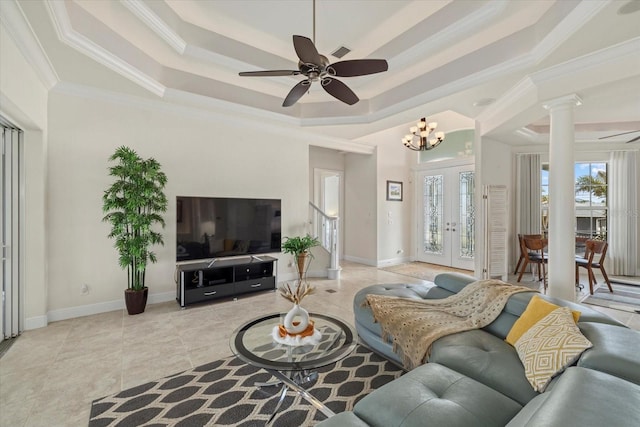 tiled living room with a raised ceiling, french doors, ceiling fan with notable chandelier, and ornamental molding