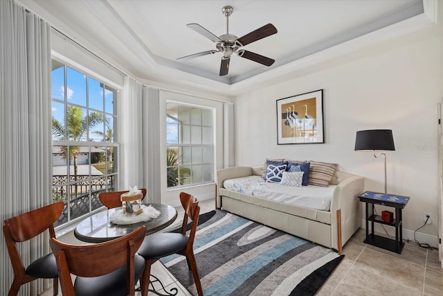 bedroom featuring light tile patterned floors, a tray ceiling, and ceiling fan