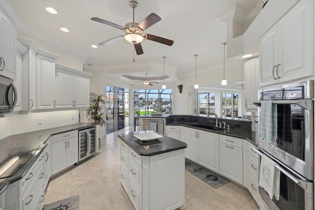 kitchen with white cabinets, sink, wine cooler, a wealth of natural light, and kitchen peninsula