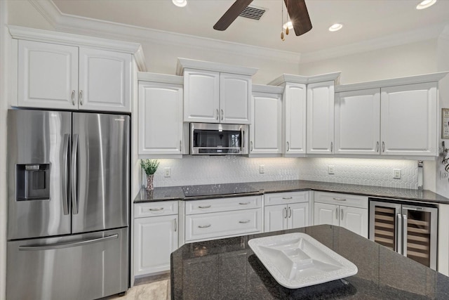 kitchen with backsplash, dark stone countertops, white cabinets, and stainless steel appliances