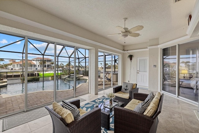 sunroom featuring a water view and ceiling fan