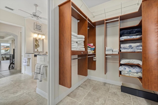 spacious closet with ceiling fan and light tile patterned floors