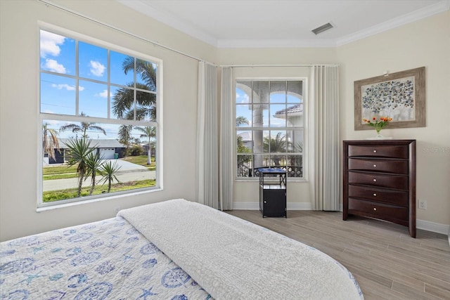 bedroom with light hardwood / wood-style floors and ornamental molding