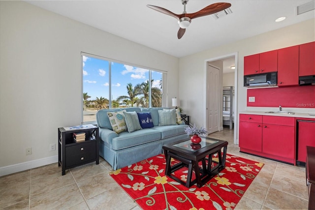 living room featuring ceiling fan, light tile patterned flooring, and sink