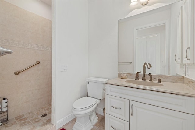 bathroom featuring vanity, toilet, and a tile shower