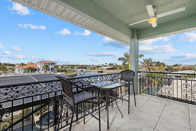 balcony with ceiling fan and a water view