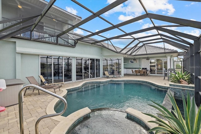 view of pool with a lanai, a patio area, and an in ground hot tub