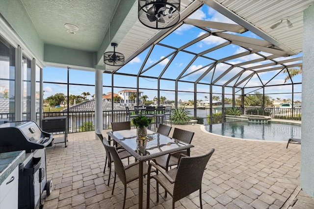 view of patio / terrace with a swimming pool with hot tub, a water view, and a lanai