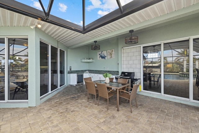 view of patio with glass enclosure and grilling area