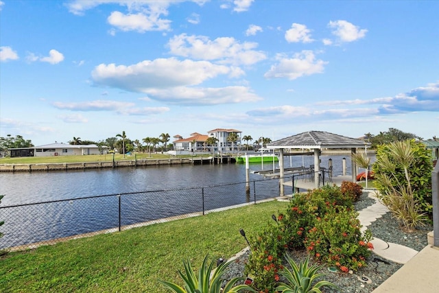 view of dock with a lawn and a water view