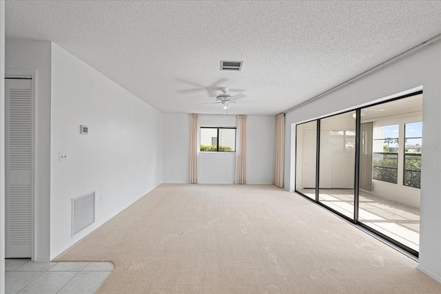 carpeted spare room featuring a textured ceiling and ceiling fan