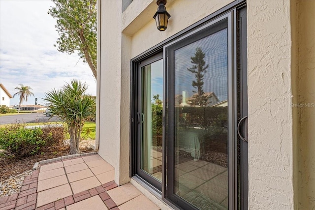 view of exterior entry with a patio area