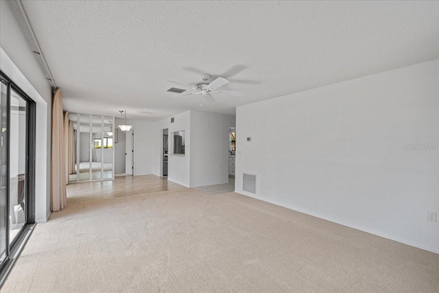 carpeted spare room with ceiling fan and a textured ceiling