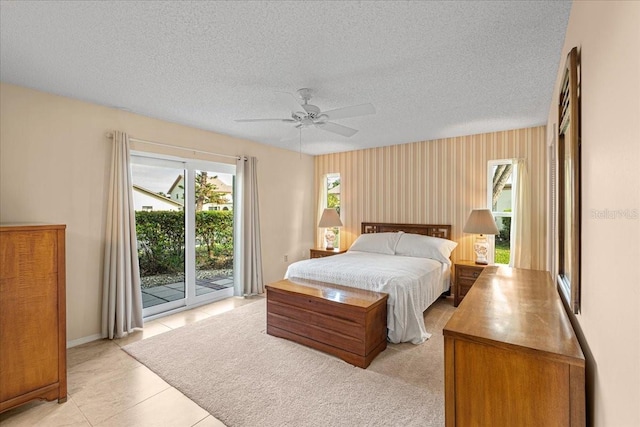 tiled bedroom with access to exterior, a textured ceiling, and ceiling fan