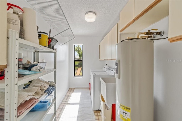 clothes washing area featuring cabinets, washing machine and dryer, electric water heater, and sink