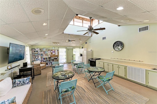 carpeted living room with high vaulted ceiling and ceiling fan