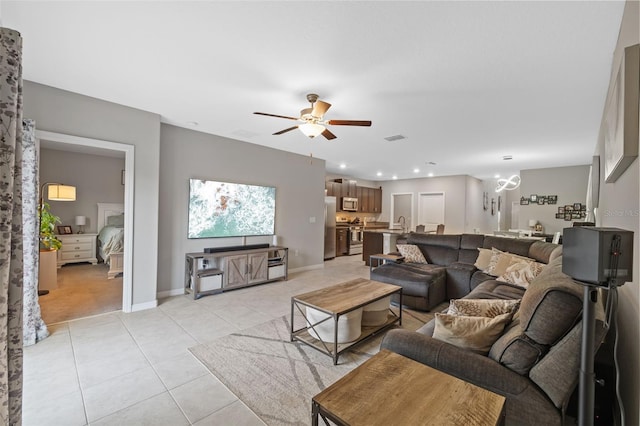 living room featuring ceiling fan, sink, and light tile patterned floors