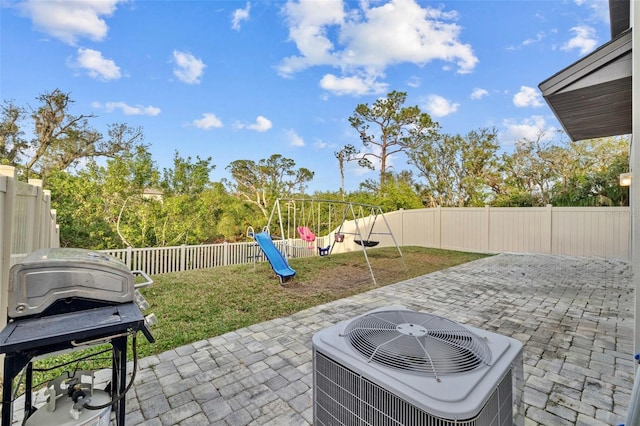 view of patio / terrace with grilling area, cooling unit, and a playground