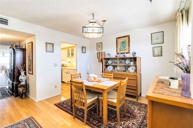 dining area with hardwood / wood-style flooring and a textured ceiling