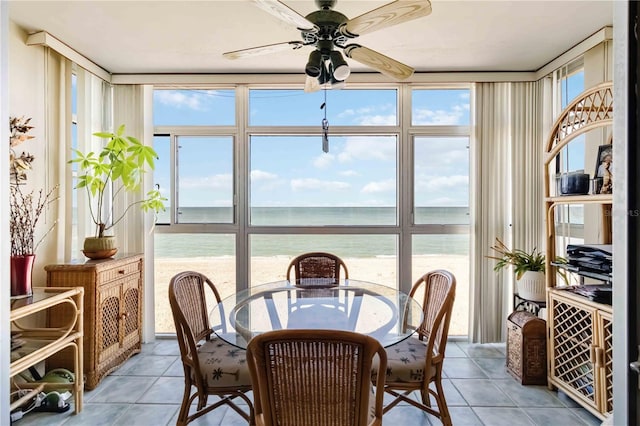 sunroom / solarium featuring ceiling fan, a water view, and a wealth of natural light