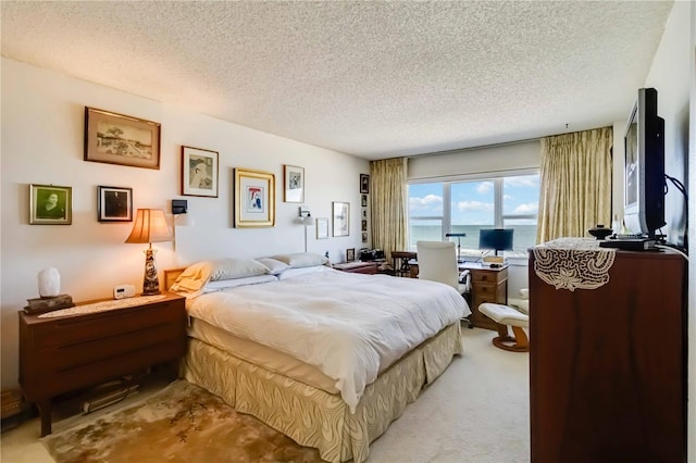 bedroom featuring light colored carpet and a textured ceiling