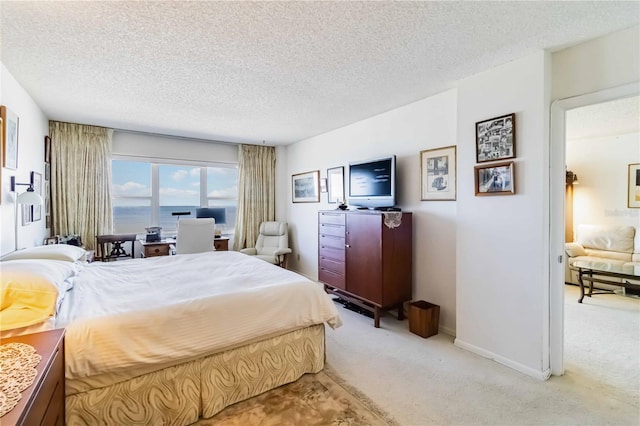 bedroom with a textured ceiling and light carpet