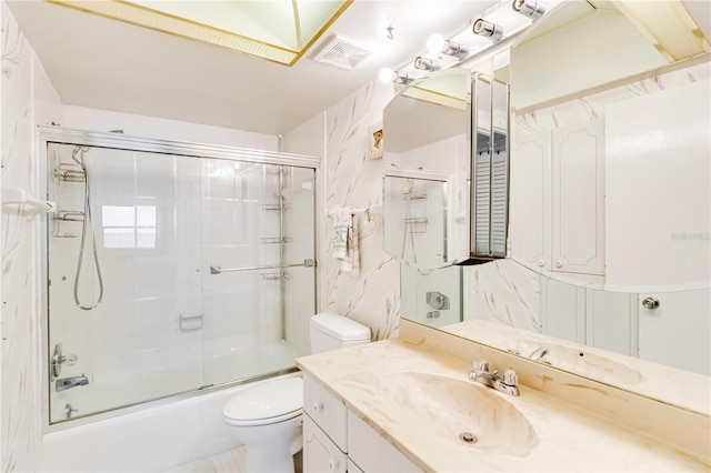 full bathroom with combined bath / shower with glass door, toilet, and vanity