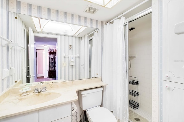 bathroom with toilet, vanity, and walk in shower