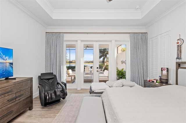 bedroom with a raised ceiling, crown molding, and access to outside