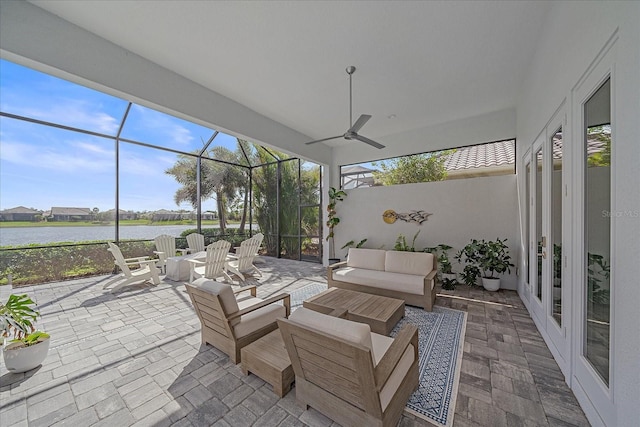 sunroom with a water view, a wealth of natural light, and a ceiling fan