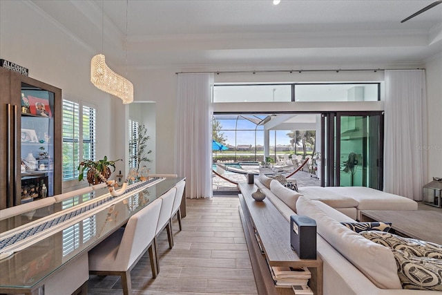 interior space featuring a high ceiling, wood finished floors, a sunroom, and crown molding