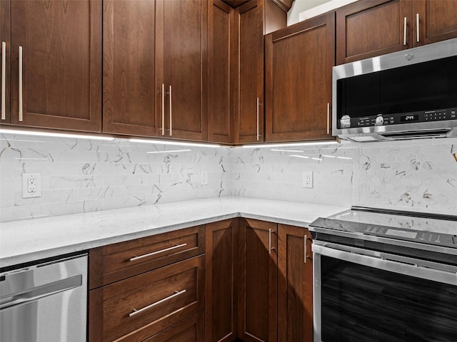 kitchen featuring light stone countertops, backsplash, and stainless steel appliances