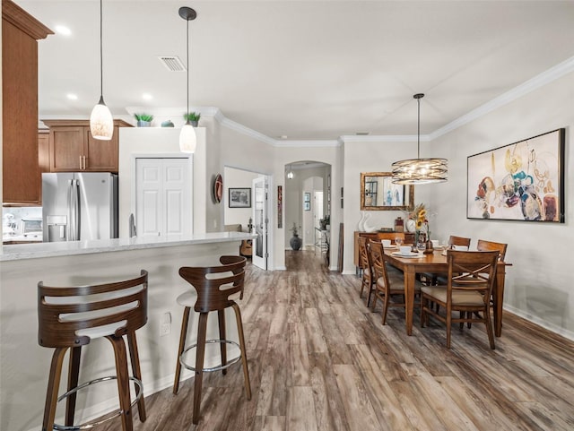 dining room with dark hardwood / wood-style flooring and crown molding