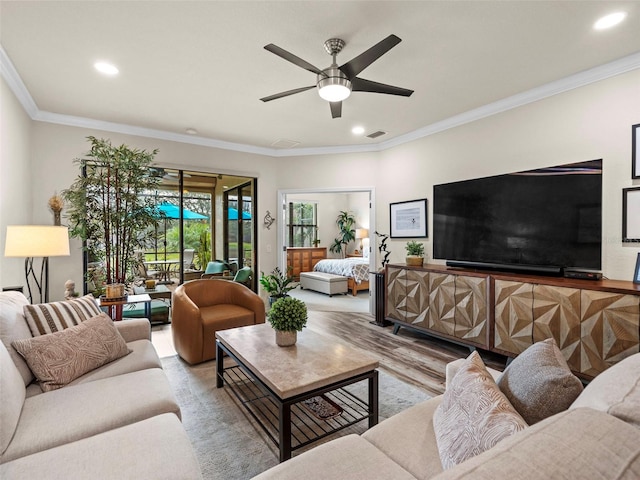 living room with ceiling fan, light wood-type flooring, and crown molding