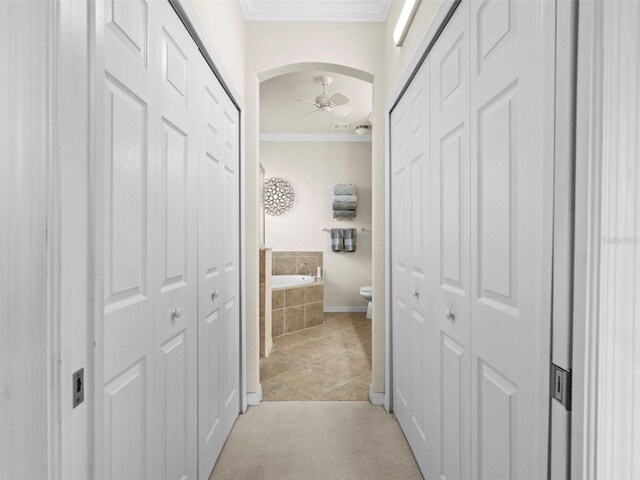 hallway with light tile patterned flooring and ornamental molding